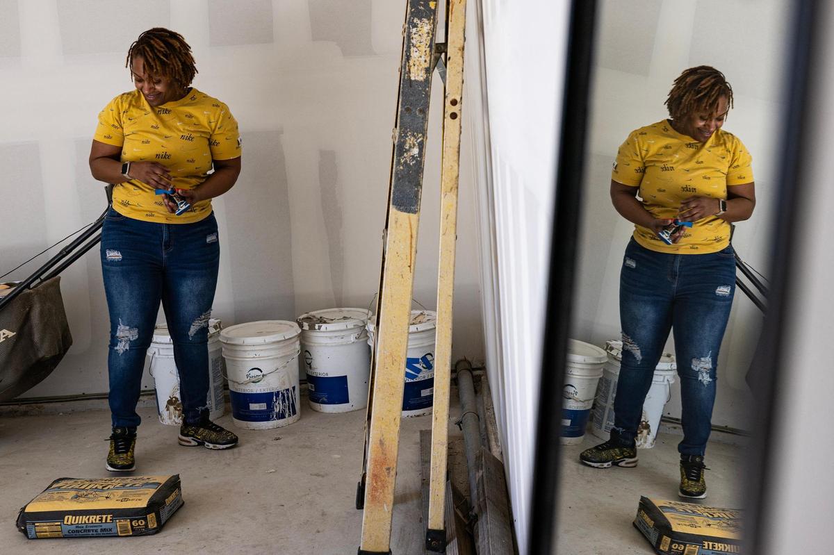 Smith standing by tools in her garage. She’s still adjusting to the routine maintenance required of homeownership, though she enjoys the challenges.
