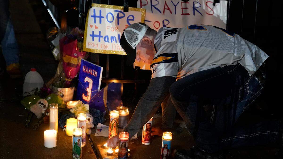 Brandon Metzger lights candles before a prayer vigil for Buffalo Bills’ Damar Hamlin outside of the University of Cincinnati Medical Center this week.