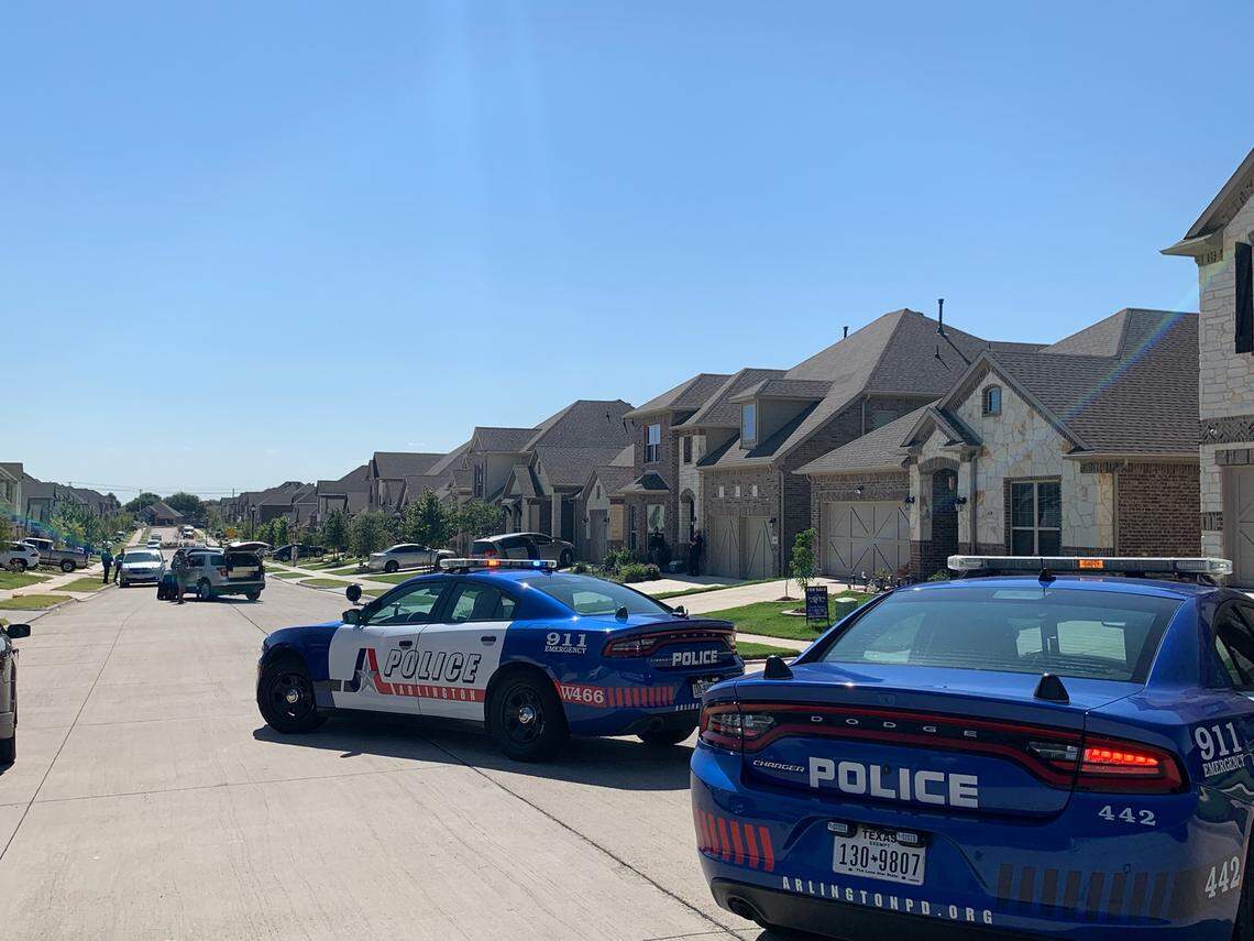Police surround a home in Arlington, Texas, as they search for the suspect in a school shooting.