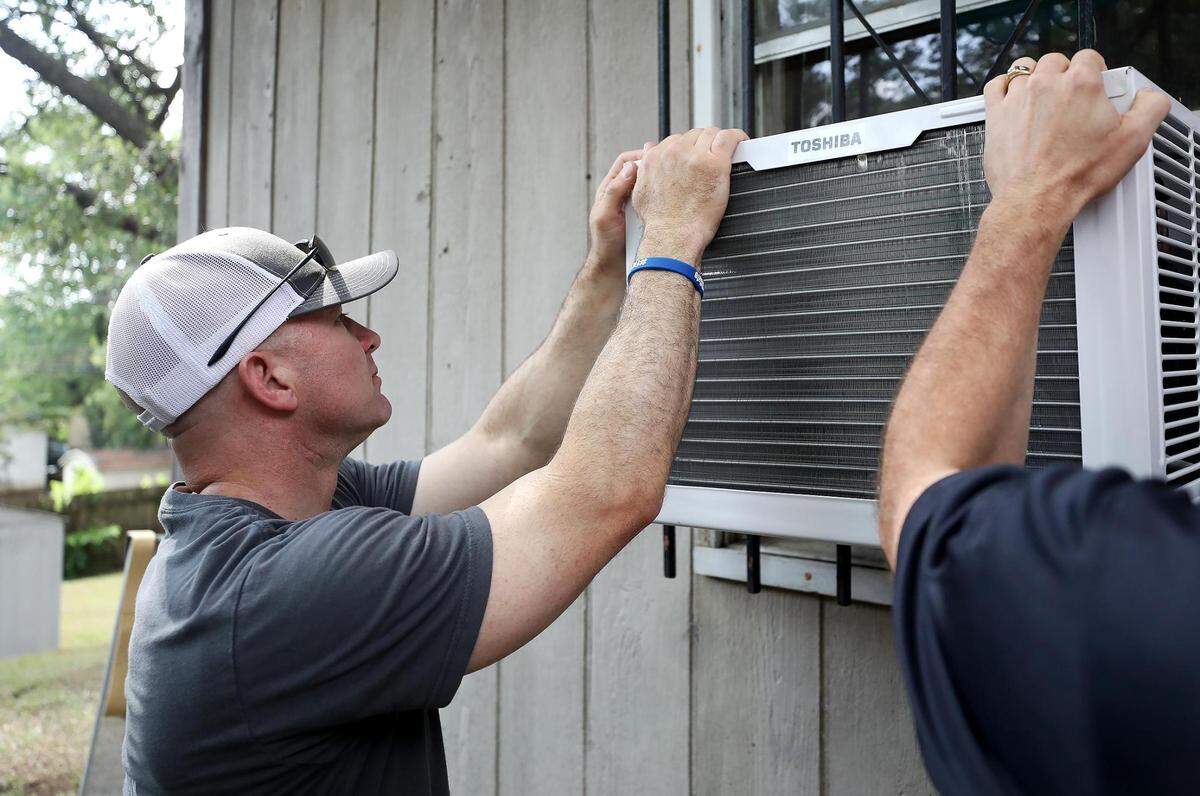 Fort Worth Police Chief Neil Noakes helps to install an air conditioning unit at Lanell Hayward Harris’ southeast Fort Worth home on July 15, 2021. Members of the police department were working to engage with the public and learn what needs a neighborhood might have as part of the #FortWorthSafe initiative.