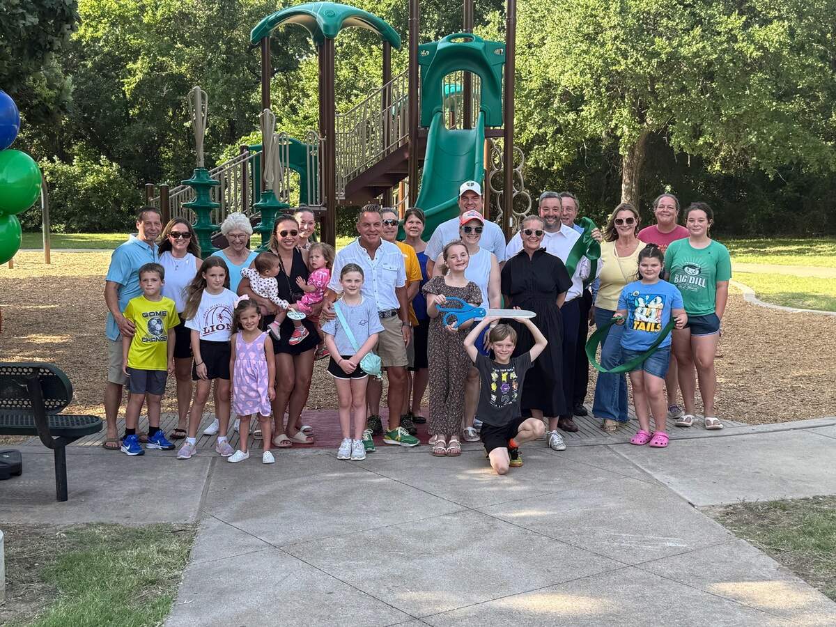 Community members embrace one another at the reopening of Oakmont Park.