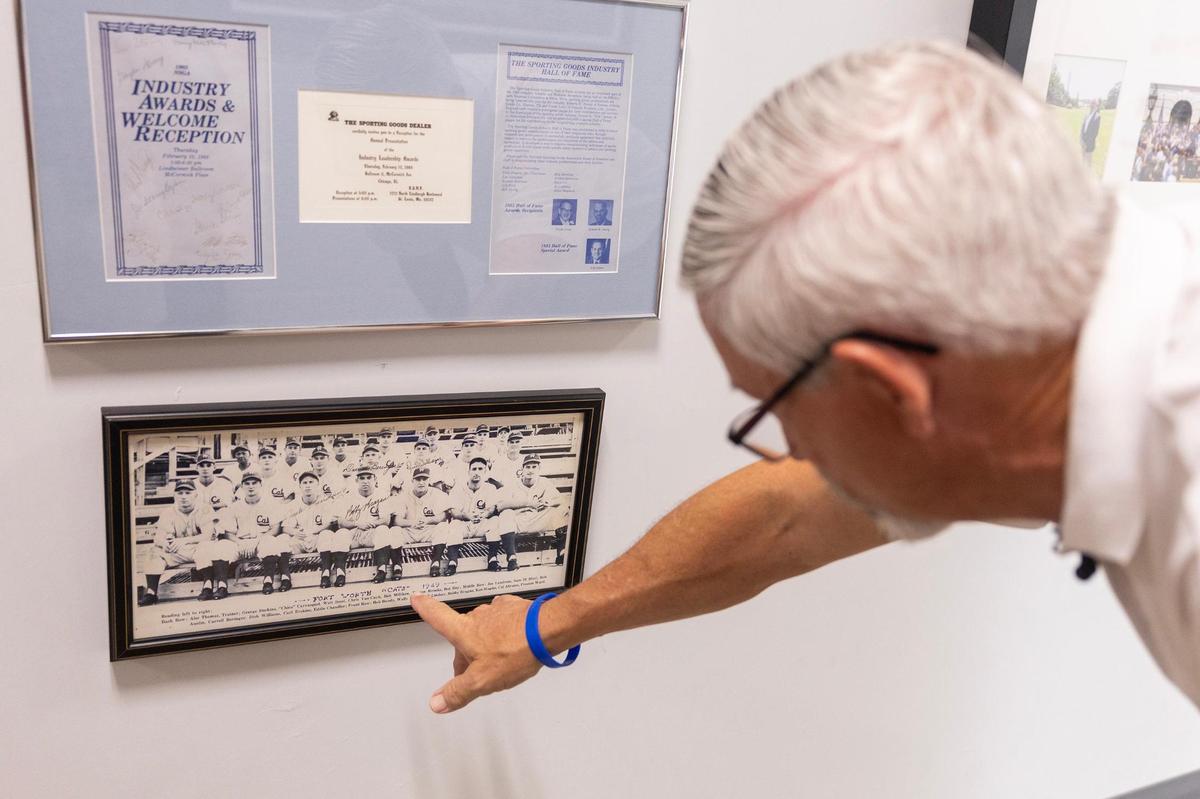 Nokona co-owner Rob Storey, the great-grandson of the company’s founder, points at a photo of the Fort Worth Cats in 1949 wearing Nokona gear.