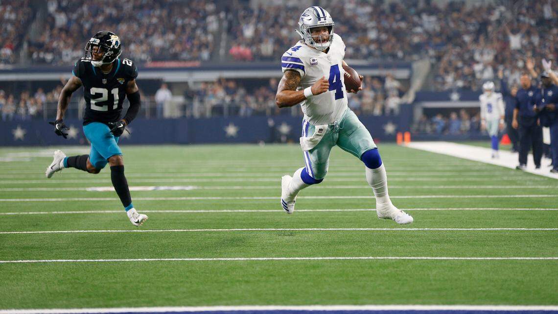Dallas Cowboys quarterback Dak Prescott (4) runs the ball as Jacksonville Jaguars cornerback A.J. Bouye (21) defends in the first half of an NFL football game in Arlington, Texas, Sunday, Oct. 14, 2018. Prescott would score a touchdown on the play.