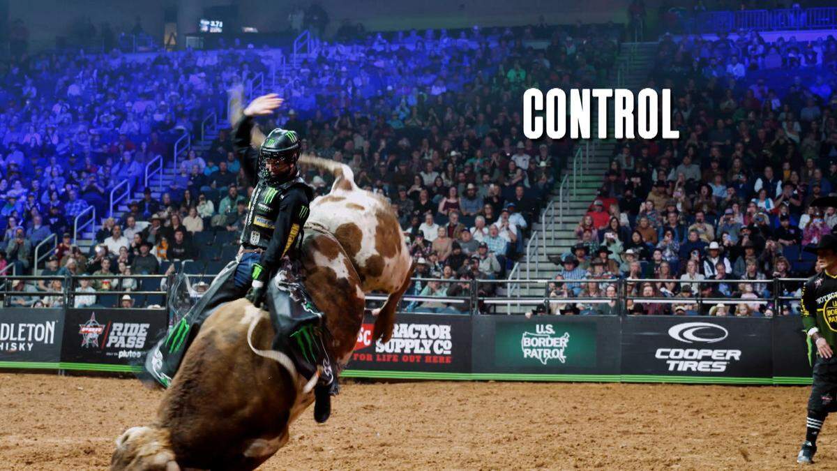 A rider maintaining control while on a bull.