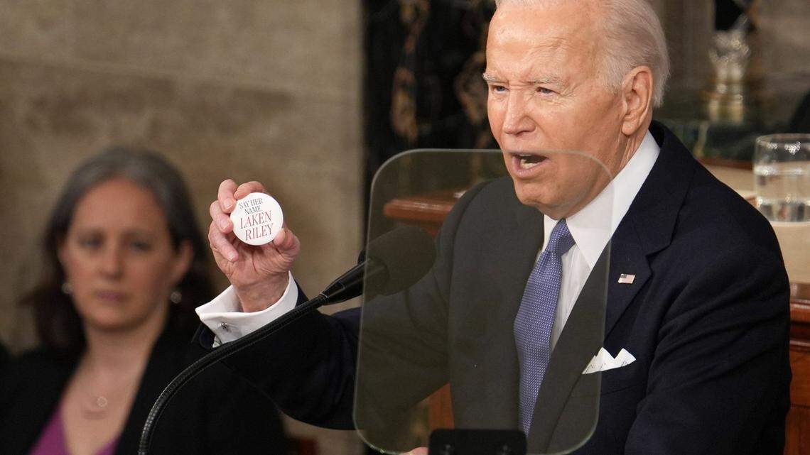 President Joe Biden holds a button honoring 22-year-old Laken Riley, a nursing student whose body was found in a wooded area on the University of Georgia’s main campus in Athens, Ga. A person in the country illegally was charged in the killing, and Republicans jeered at Biden to mention Riley in his state of the union address Thursday night.