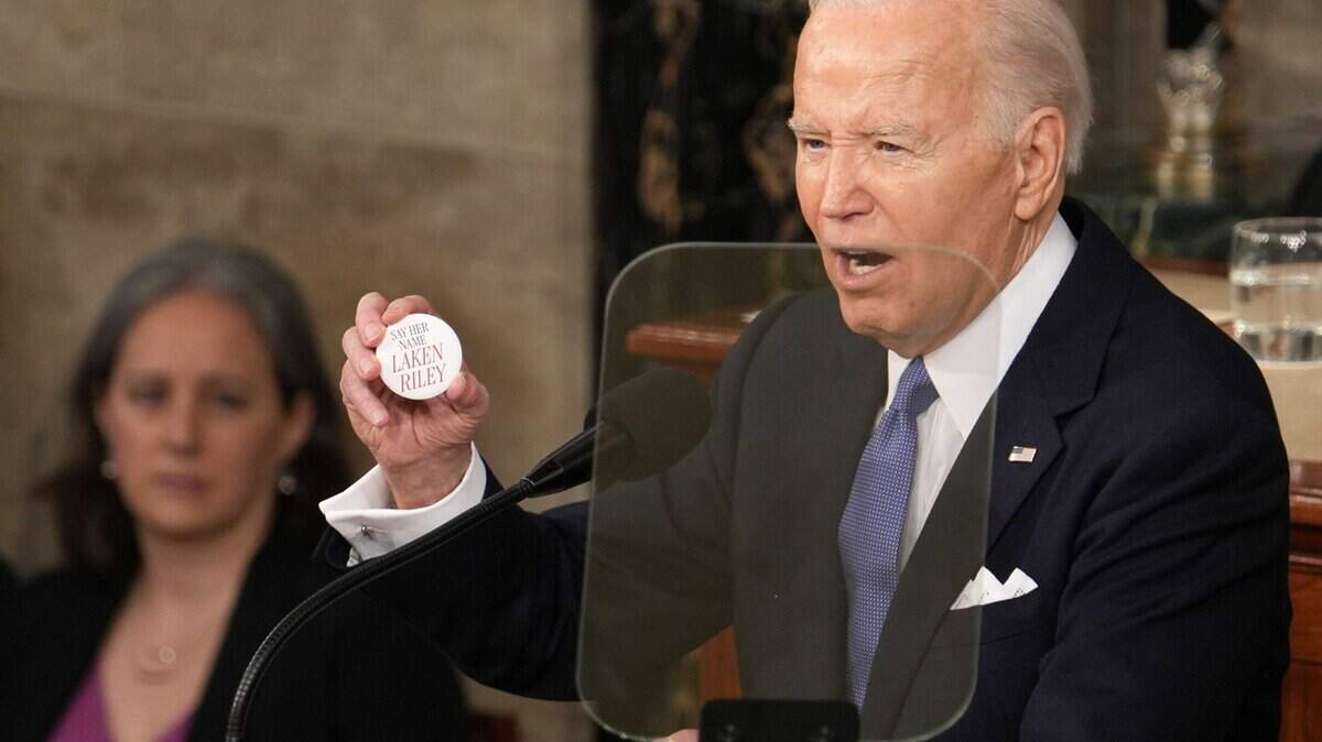 President Joe Biden holds a button honoring 22-year-old Laken Riley, a nursing student whose body was found in a wooded area on the University of Georgia’s main campus in Athens, Ga. A person in the country illegally was charged in the killing, and Republicans jeered at Biden to mention Riley in his state of the union address Thursday night.