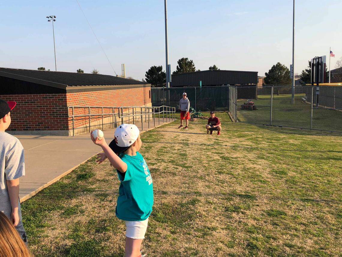 Khloe Brandon, 9, throws out the first pitch during the Keller Central baseball game, Tuesday March 19, 2019.