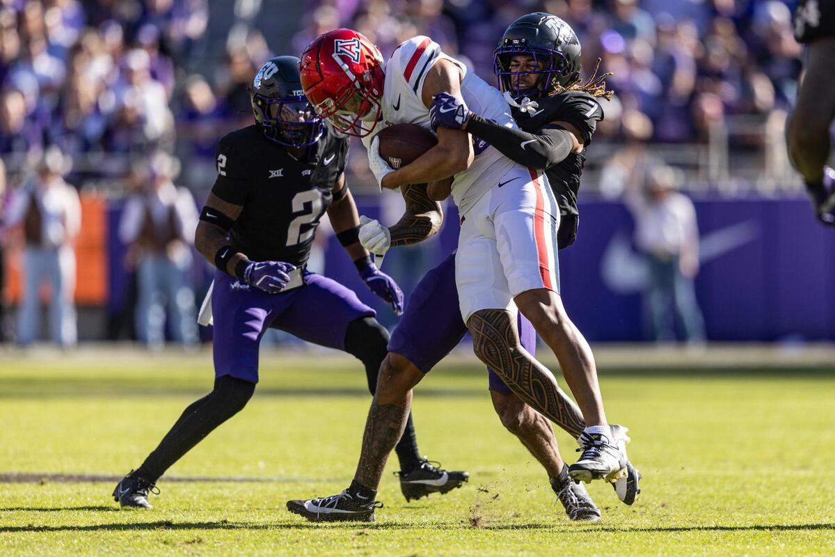 TCU cornerback Channing Canada (7) picks up Arizona wide receiver Tetairoa McMillan (4) after a reception in the first half of a NCAA football game at Amon G. Carter Stadium in Fort Worth on Saturday, Nov. 23, 2024.