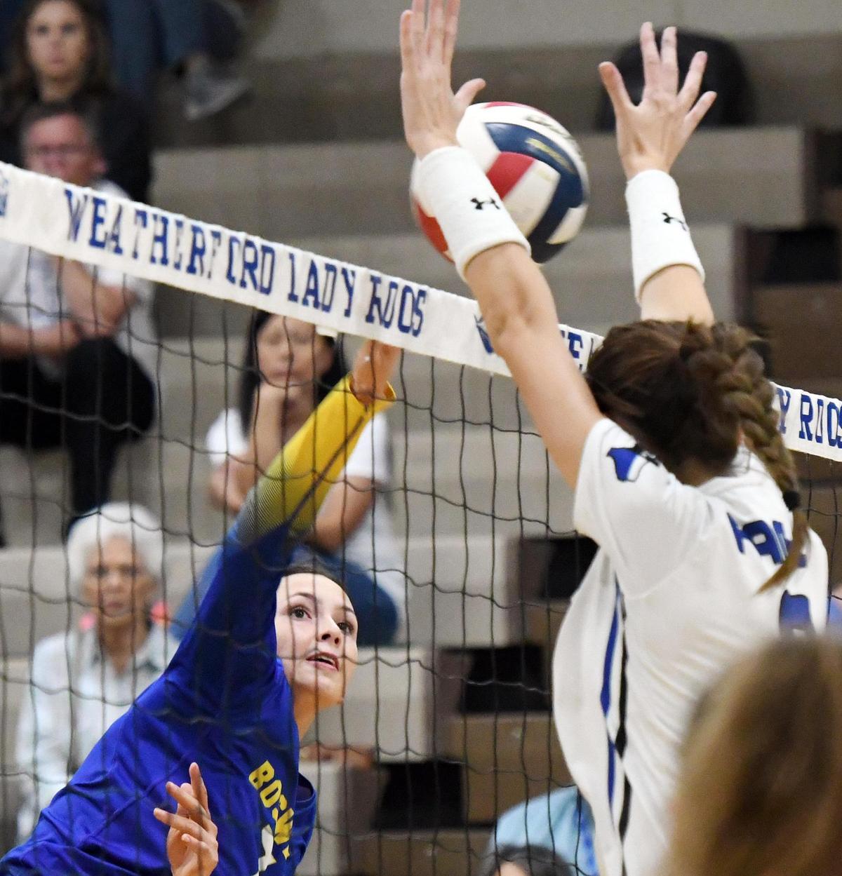 Boswell’s Madi Parrish, left, gets the ball over the net as Weatherford’s Berkley Austin Roark tries to block during the second game of Tuesday’s September 27, 2022 District 3-6A volleyball match in Weatherford Texas. Boswell won the match, 25-15, 25-16, 21-25 and 25-22. Special/Bob Haynes