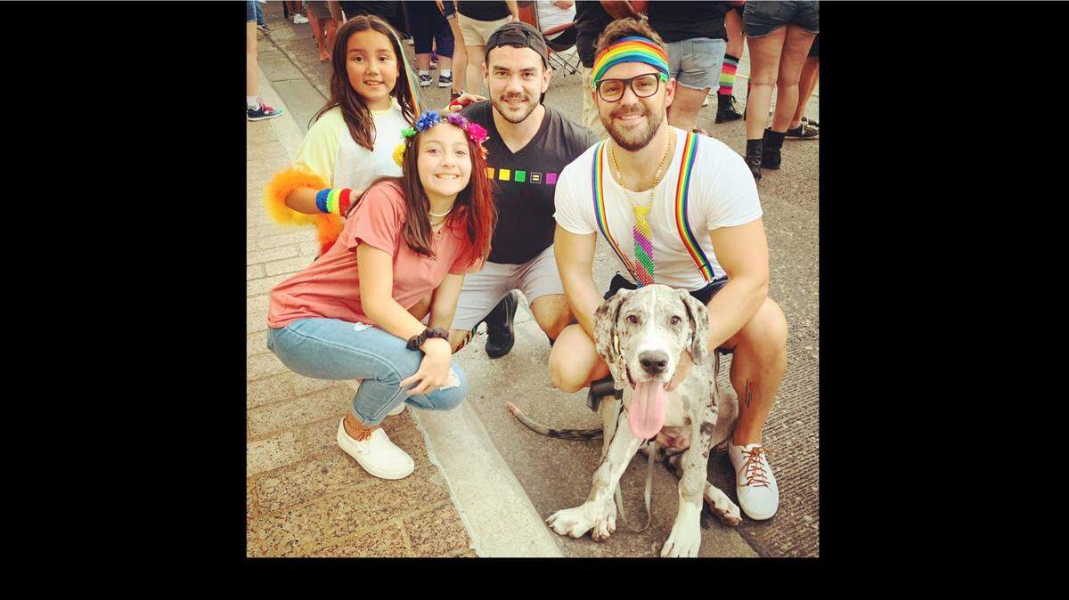 Newlyweds David Colligan and Alonzo Rivas, seen here with their two daughters, are facing steep fines from their HOA for displaying a Pride flag in front of their home in Austin.