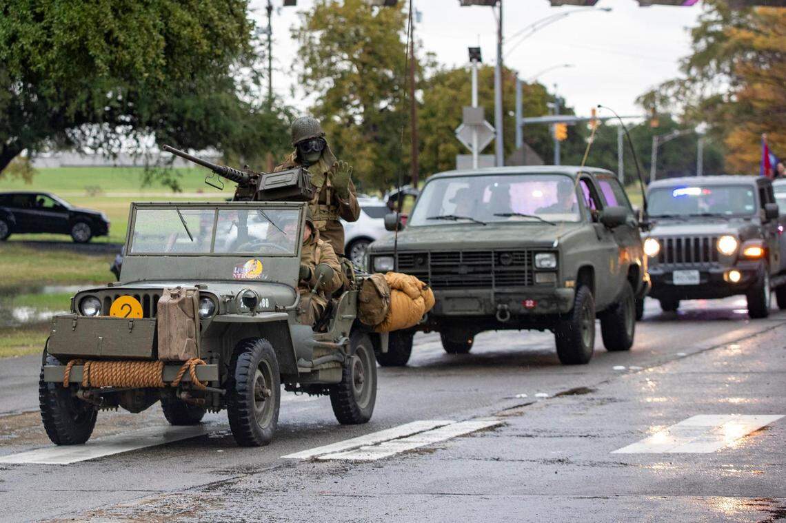 A military vehicle in the Veterans Day Parade winds through Fort Worth on Friday, Nov. 11, 2022. Despite rain, hundreds of participants marched down North Forest Park Boulevard, waving American flags and signing a medley of military songs.