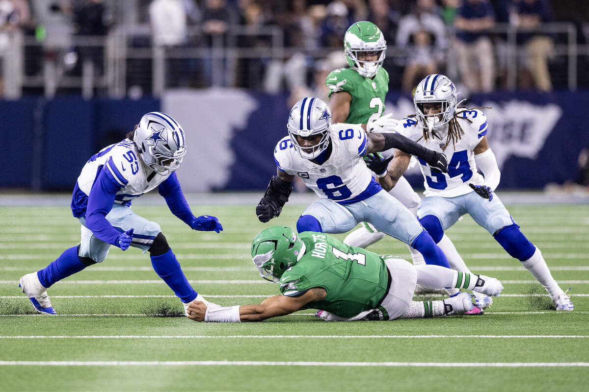 Eagles quarterback Jalen Hurts (1) slides down before he could get sacked by multiple Cowboys defenders in the second half of an NFL game between the Dallas Cowboys and the Philadelphia Eagles at AT&T Stadium in Arlington on Sunday, Nov. 23, 2025.