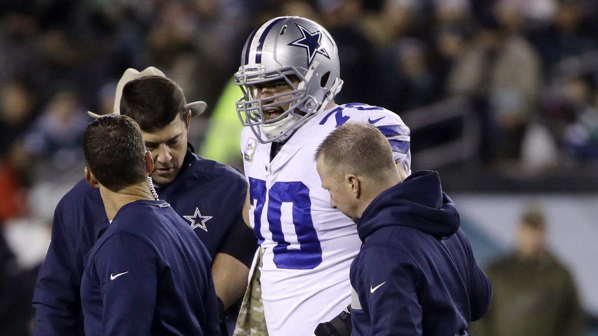 Dallas Cowboys guard Zack Martin is helped off the field by trainers after injuring his left knee during the first half of Sunday night’s game against the Philadelphia Eagles. Martin hurt the same knee last month against Houston.