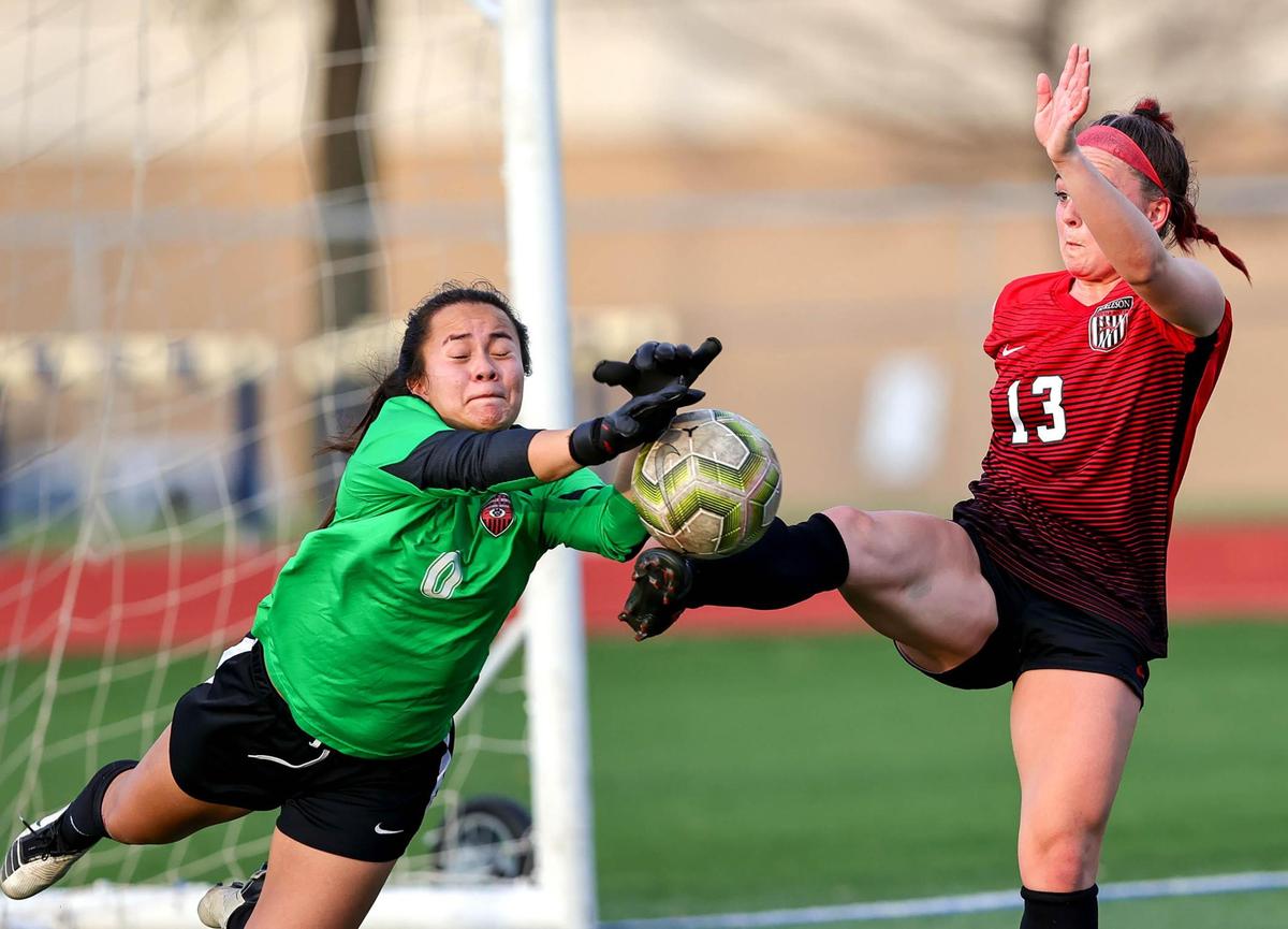 Colleyville Heritage goaltender Juliana Grider (0) makes a save against Burleson’s Maycie Massingill (13) during overtime in the 5A Region 1 area round girls soccer playoffs played on March 30 2021, at Cravens Field in Arlington, TX. (Steve Nurenberg Special to the Star-Telegram)