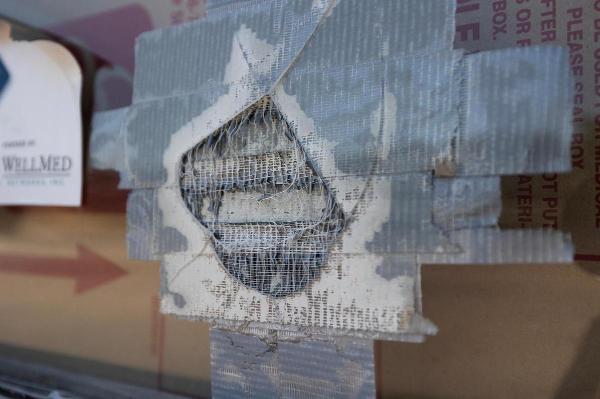 Duct tape is used to patch a broken window at Extra Care Concerns on East Lancaster Street. Vandalism happens so often that its not cost effective to continually replace the windows, said manager Taja Harris.