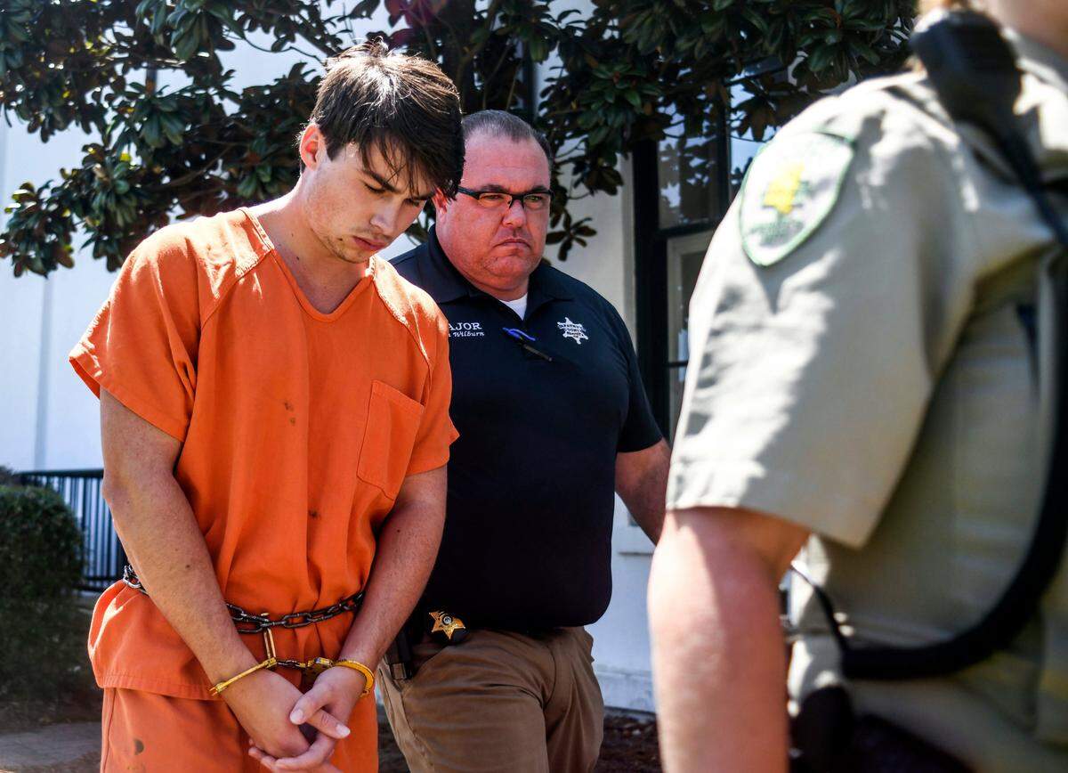Brandon Theesfeld, left, is led from the Lafayette County Courthouse in Oxford, Miss., Tuesday, July 23, 2019 by Maj. Alan Wilburn, after being arraigned in connection with the death of 21-year-old University of Mississippi student Alexandria “Ally” Kostial.