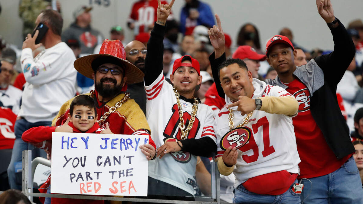 San Francisco 49ers fans pose for photos before an NFL wild card game against the Dallas Cowboys at AT&T Stadium in Arlington.