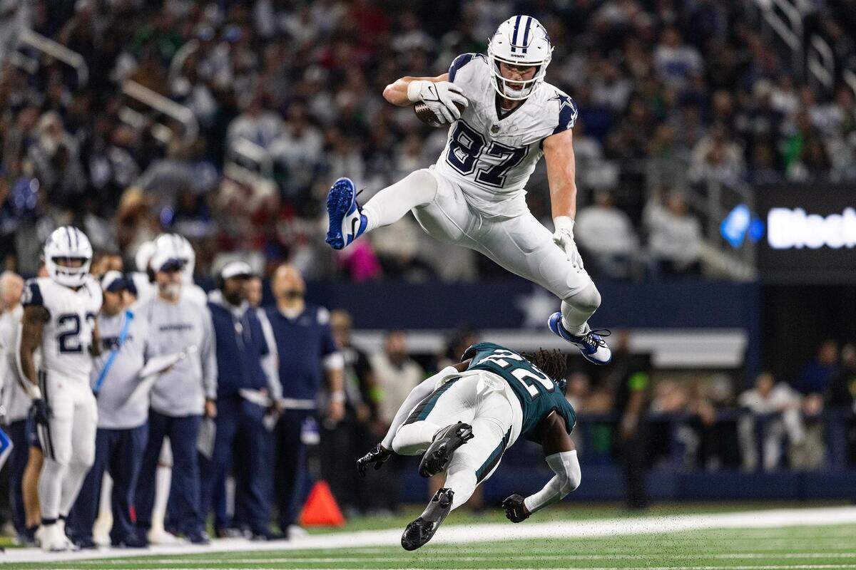 Cowboys tight end Jake Ferguson (87) hurdles Eagles cornerback Kelee Ringo (22) during the third quarter on Thursday, Dec. 10, 2023.