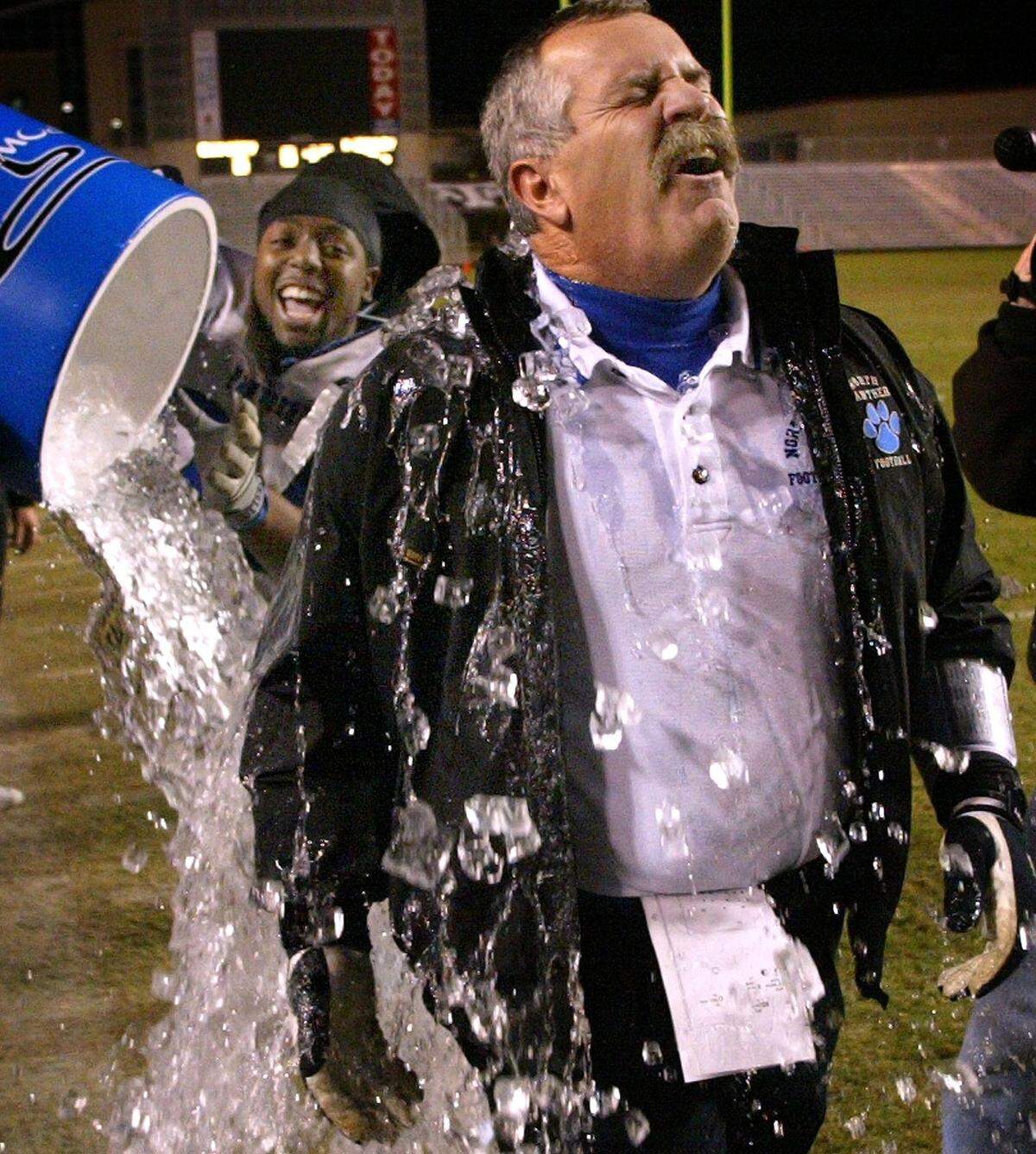 North Crowley head coach Mike Papas (right) is drenched with water by some of his players with seconds remaining in the game. North Crowley wins 20-6. Texas high school football state championship game. North Crowley High vs Bay City High for the 4A Division 1 state title at Kyle Field in College Station, Texas, Saturday, December 13, 2003. (Star-Telegram/Ron Jenkins)