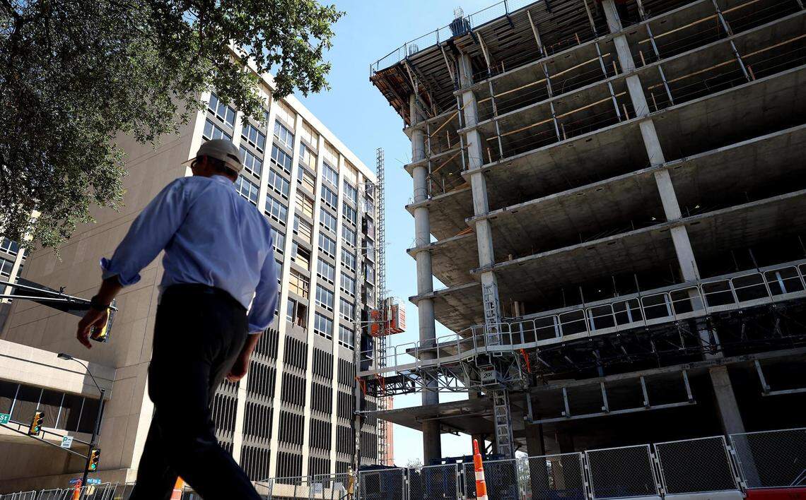 A pedestrian walks on Commerce Street as construction continues on the upcoming Le Méredien on Wednesday, July 27, 2022, in downtown Fort Worth. The hotel is expected to open in 2023.