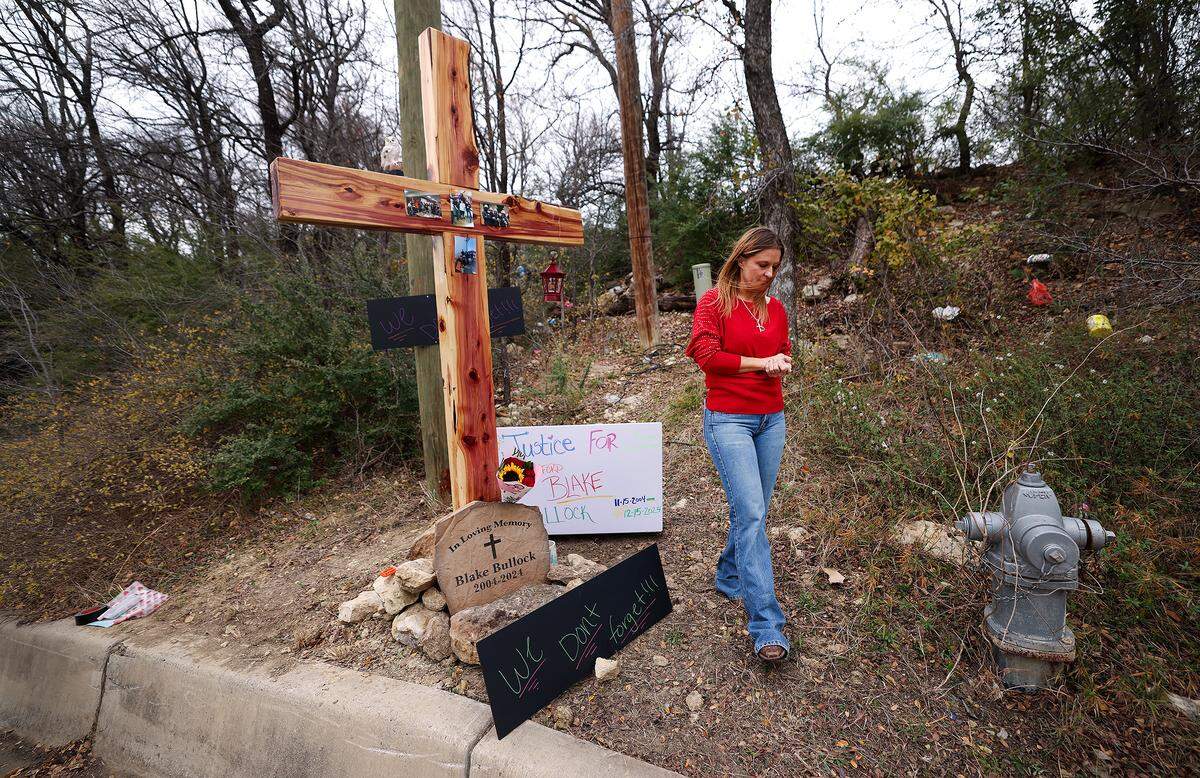 Amy Spurlock walks away from a cross placed in memory of her son, Blake, on Tuesday, Dec. 16, 2025. Spurlock is searching for answers about the night her son died over a year ago on Northwest 20th Street in Fort Worth. 