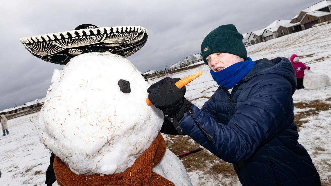 Jude Welch, 14, attaches the carrot nose to the snowman that he and his friends built at their neighborhood park in southwest Fort Worth on Friday, Jan. 10, 2025.
