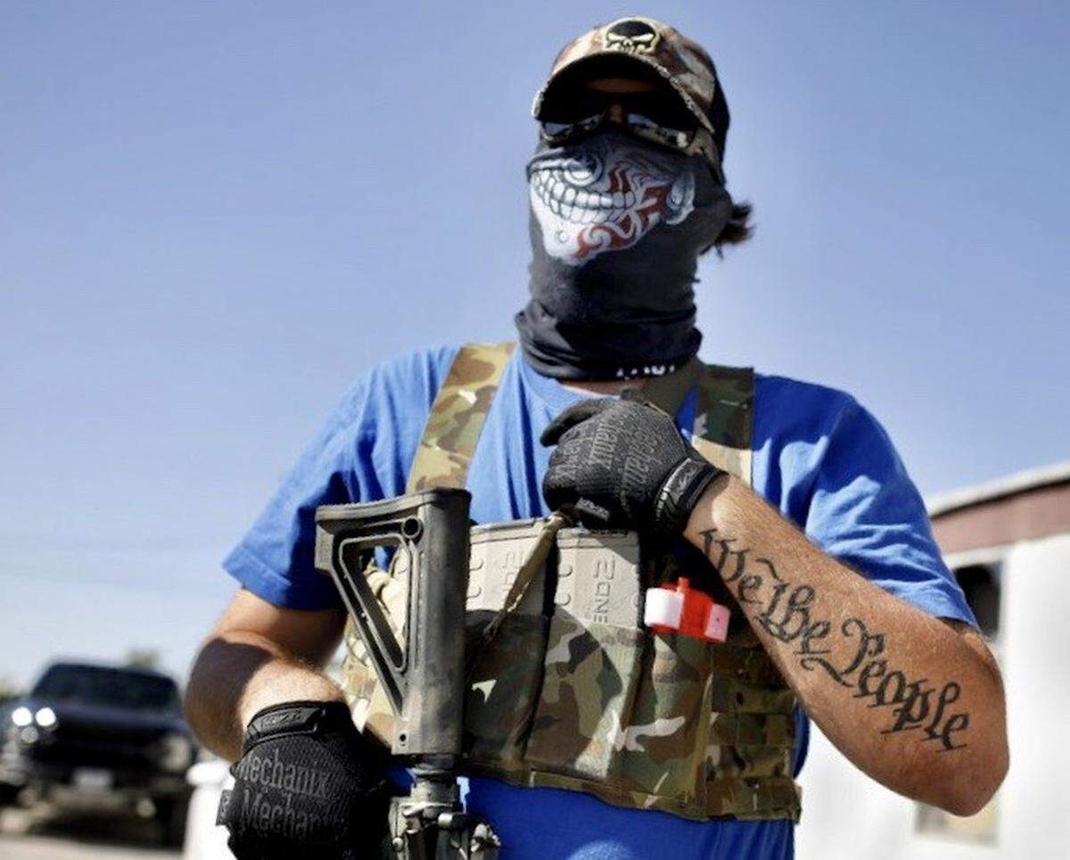 Armed protester Wyatt Winn waits for Ector County Sheriff’s deputies and Texas state troopers shortly before his arrest at a protest Monday, May 4, 2020, at Big Daddy Zane’s bar near Odessa, Texas. Winn and others were supporting the the bar’s owner, who decided to open despite orders from the Texas governor during the coronavirus pandemic that prohibited the opening until later in May.