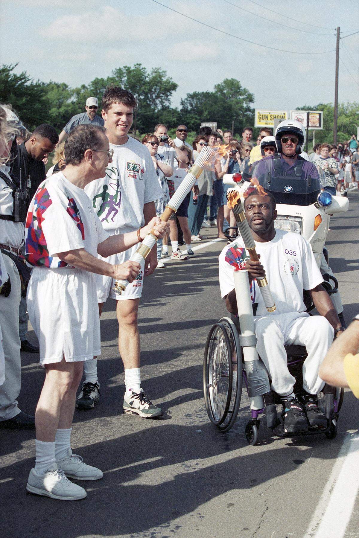 Dr. Allan Saxe, left, having his torch lit by Joe Jackson, both participating in the 1996 Olympic Torch Relay in Arlington, Texas.