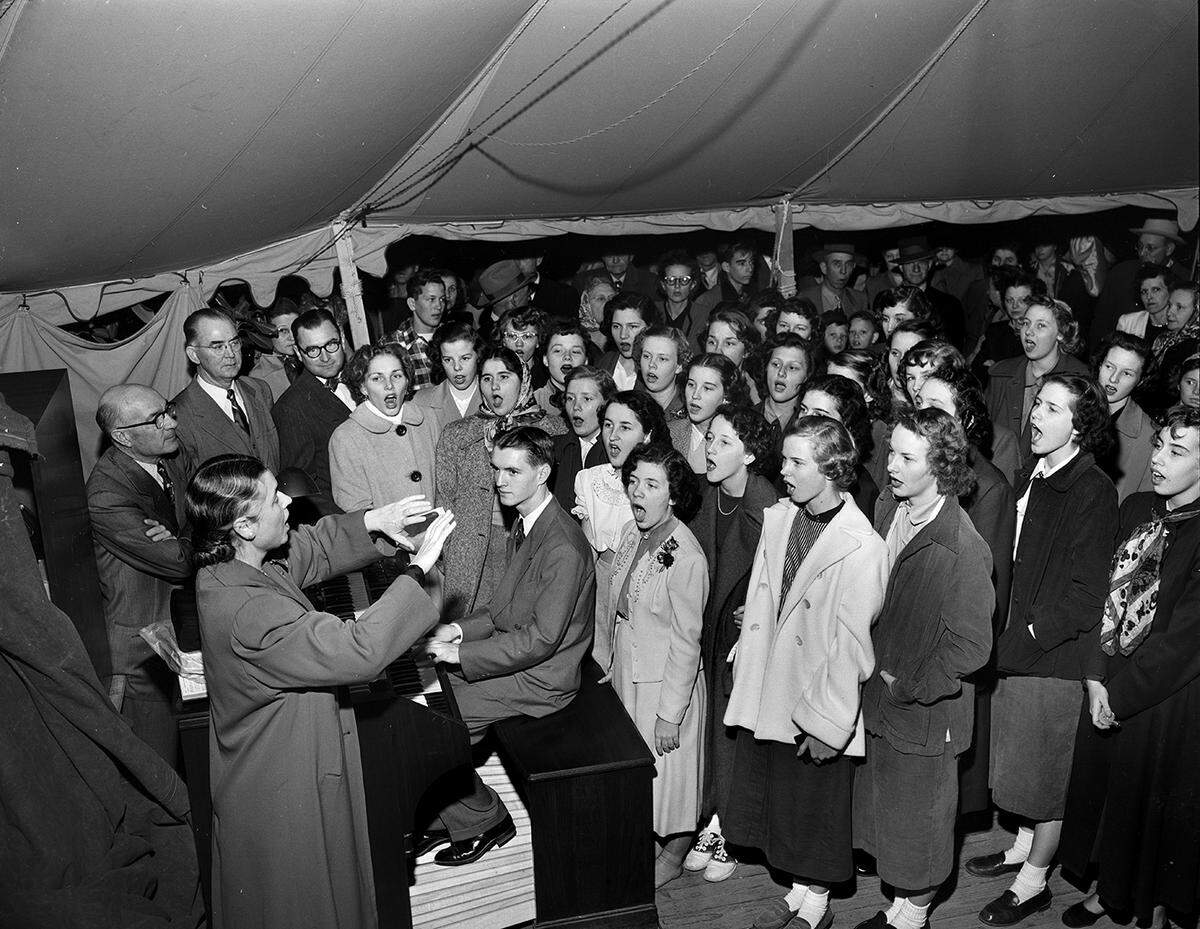 Dec. 22, 1950: The girls glee club and girls sextet of Paschal High School in Fort Worth combined talent to sing at the Star-Telegram community Christmas tree and music festival in Burnett Park. The director is Lois Ruth Mitchell, left foreground, and the organist is Cecil Bailey. The group was presented by officials of the Fort Worth Public Schools, left background. They are, from left, W.A. Meacham, assistant superintendent; Joe P. Moore, superintendent of schools; and Perry Sandifer, coordinator of music for secondary schools.