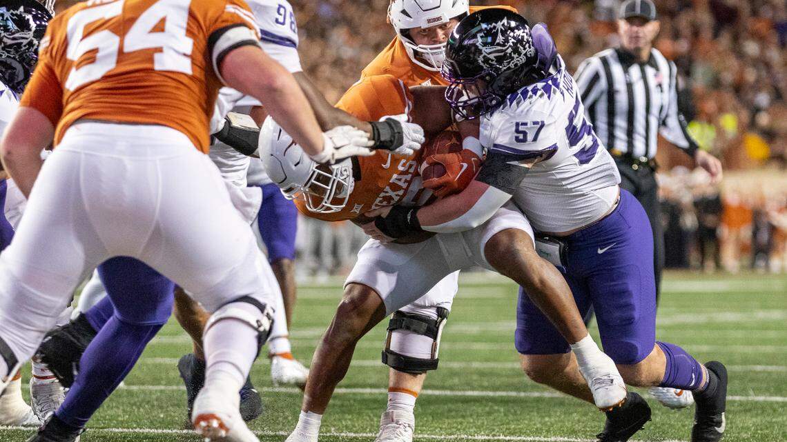 TCU linebacker Johnny Hodges (57) tackles Texas running back Bijan Robinson during the first half of an NCAA college football game Saturday, Nov. 12, 2022, in Austin, Texas.