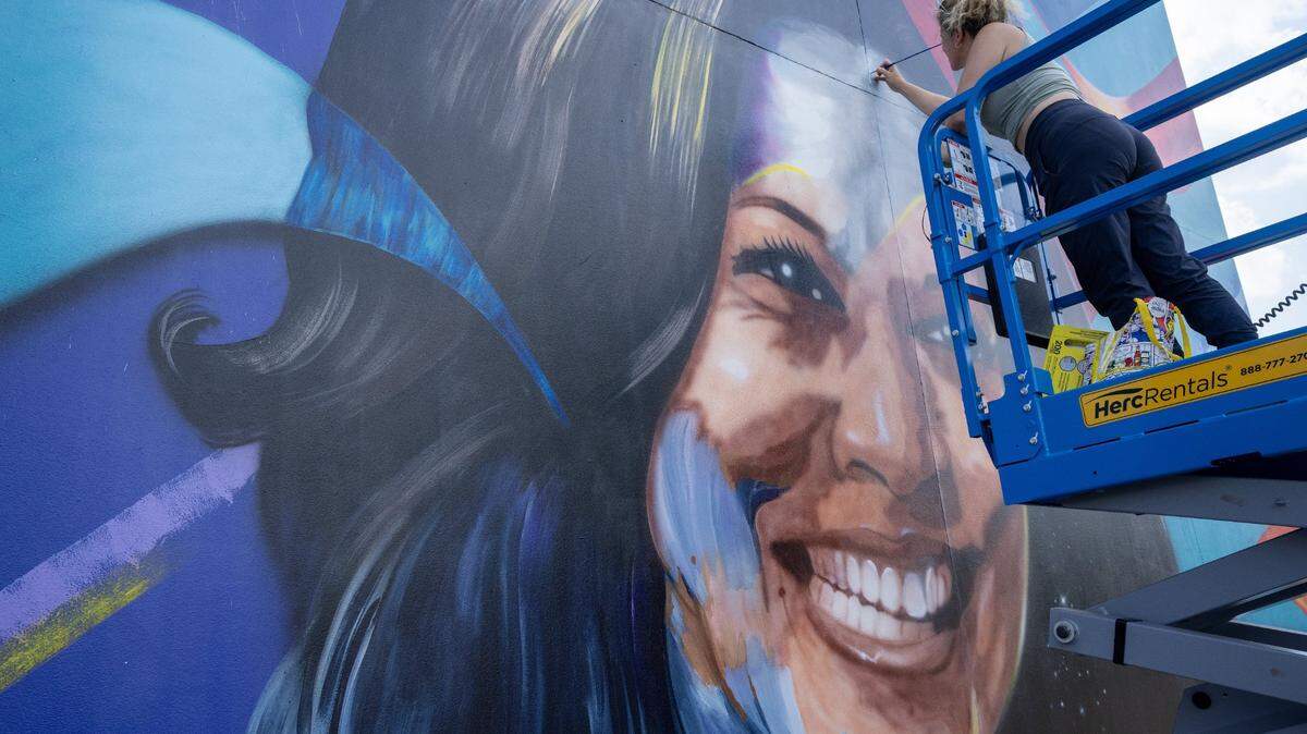 August 16, 2024; Chicago, IL;  Art restorer Lena Rush works on a mural of Vice President Kamala Harris as preparation work continues  for the Democratic National Convention at the United Center. The DNC is scheduled to take place at the United Center August 19 through August 22. The mural, created by Ian Robertson and Salt and Pique Brown, was commissioned by Emily's List in 2020. Mandatory Credit: Mark Hoffman-USA TODAY