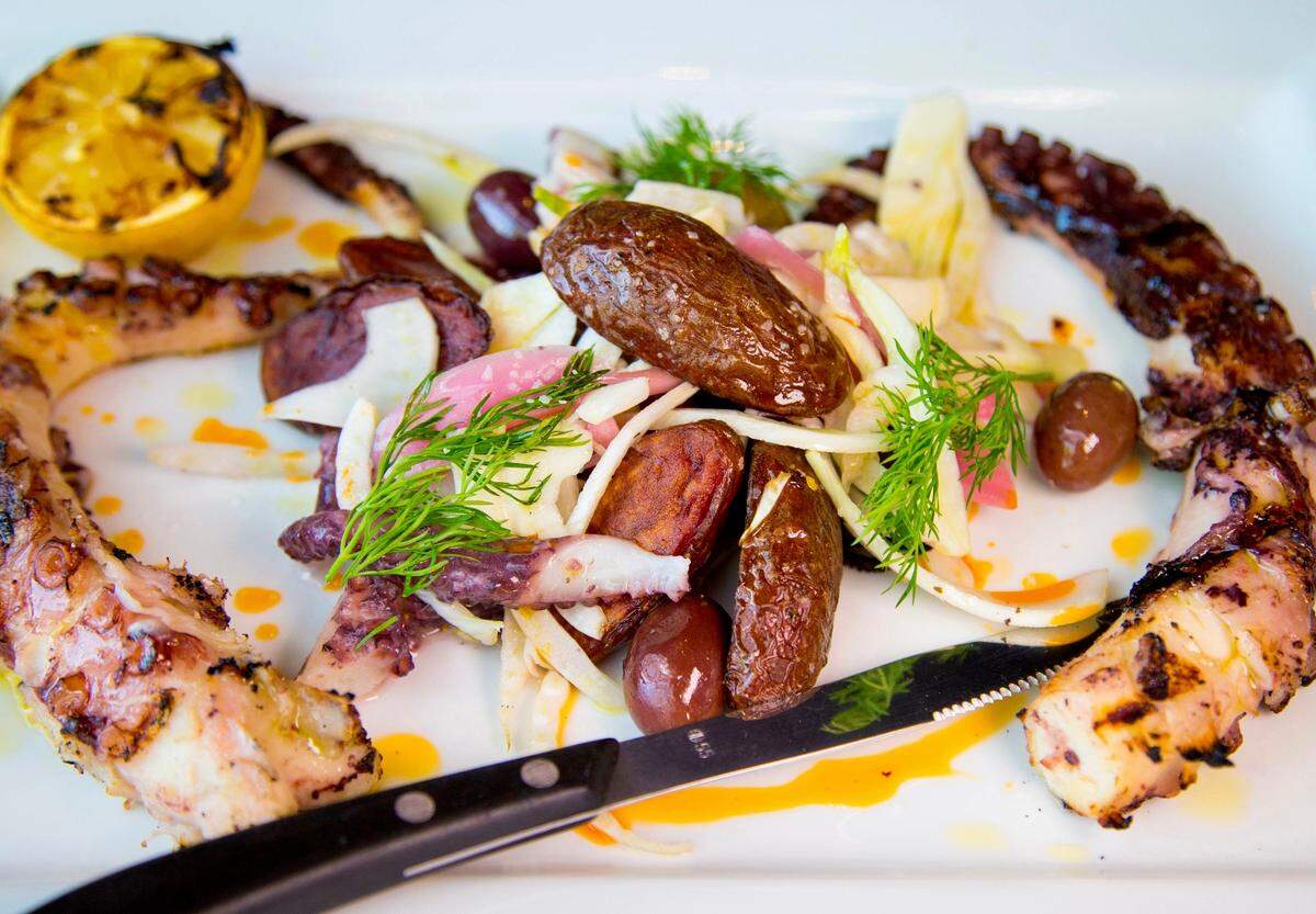 Charred octopus with shaved fennel, poached potatoes, pickled red onion, Sicilian olives, calabrian chilies, and citrus oil at The Sicilian Butcher.