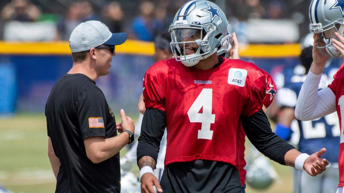 Dallas Cowboys quarterback Dak Prescott (4) talks with offensive coordinator Kellen Moore, left, during practice at the NFL football team’s training camp in Oxnard, Calif., on July 28, 2021.