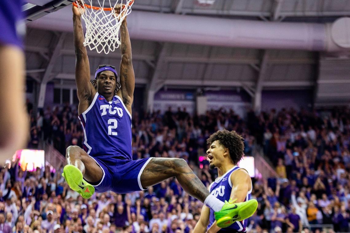 TCU forward Emanuel Miller hangs off the rim after dunking during their game against Texas at Schollmaier Arena in Fort Worth on Wednesday, March 1, 2023. TCU beat Texas 75-73.
