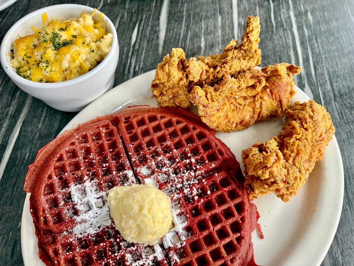 A red velvet cake waffle with chicken tenders and cheese grits at Johnny’s World Famous Chicken and Waffles in Dallas, Texas, May 1, 2025.