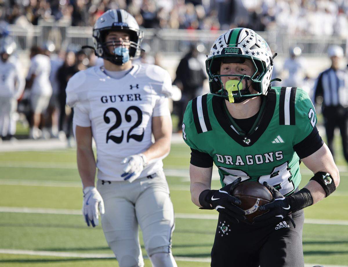 Southlake Carroll running back Brooks Biggers (24) scores ahead of Denton Guyer defensive back Owen Whistler (22) during the first half of a UIL Class 6A Division II Quarterfinal on Saturday Dec. 06, 2025 at Crowley ISD Multi-Purpose Stadium in Fort Worth, Texas.