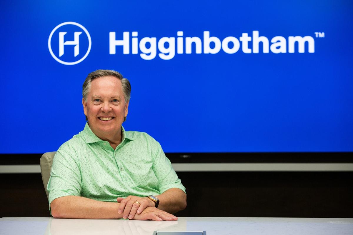 Higginbotham CEO Rusty Reid sits in front of the company’s logo on Tuesday, June 25, 2024 in Fort Worth. Higginbotham has grown significantly over the past decade, expanding their footprint beyond Texas.
