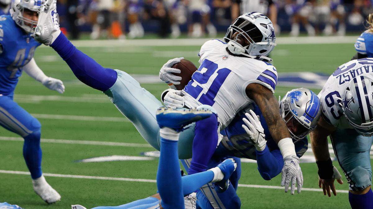 Dallas Cowboys running back Ezekiel Elliott (21) is upended by Detroit Lions cornerback Jeff Okudah (1) and linebacker Julian Okwara during Sunday’s game at AT&T Stadium.