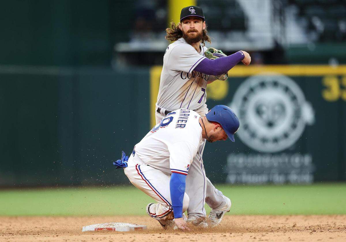 Texas Rangers catcher Mitch Garver slides into Colorado Rockies’ Brendan Rodgers during the bottom of the 10th inning on Monday, April 11, 2022, at Globe Life Field. After review the play at second base was found to be in violation of the slide rule, handing the Rockies a 6-4 win over the Rangers.
