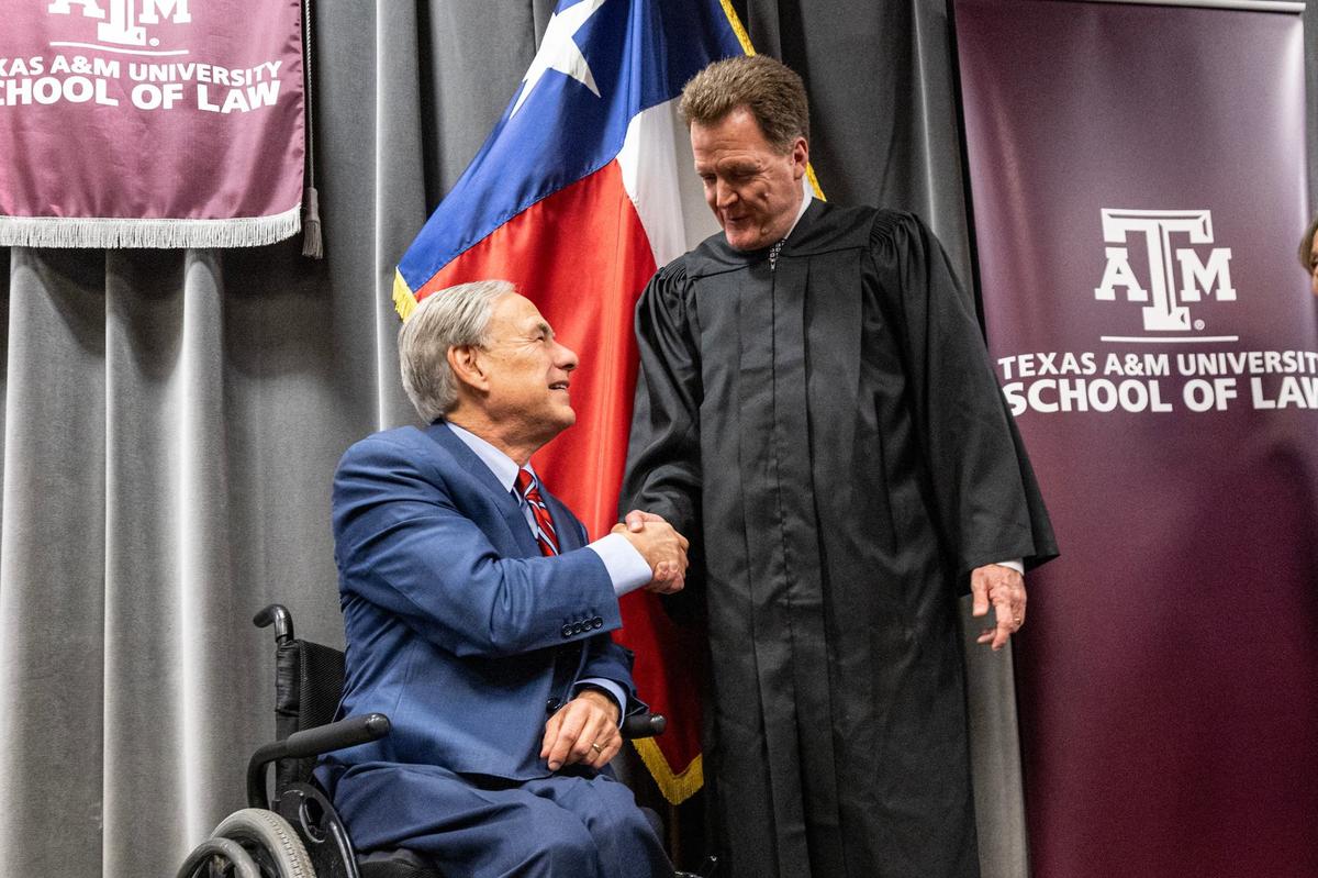 Texas Governor Greg Abbott shakes hands with newly appointed Eighth Division Business Court Justice Jerry Bullard following his official swearing in ceremony at the Texas A&M Law School in downtown Fort Worth on Thursday, Sept. 19, 2024.