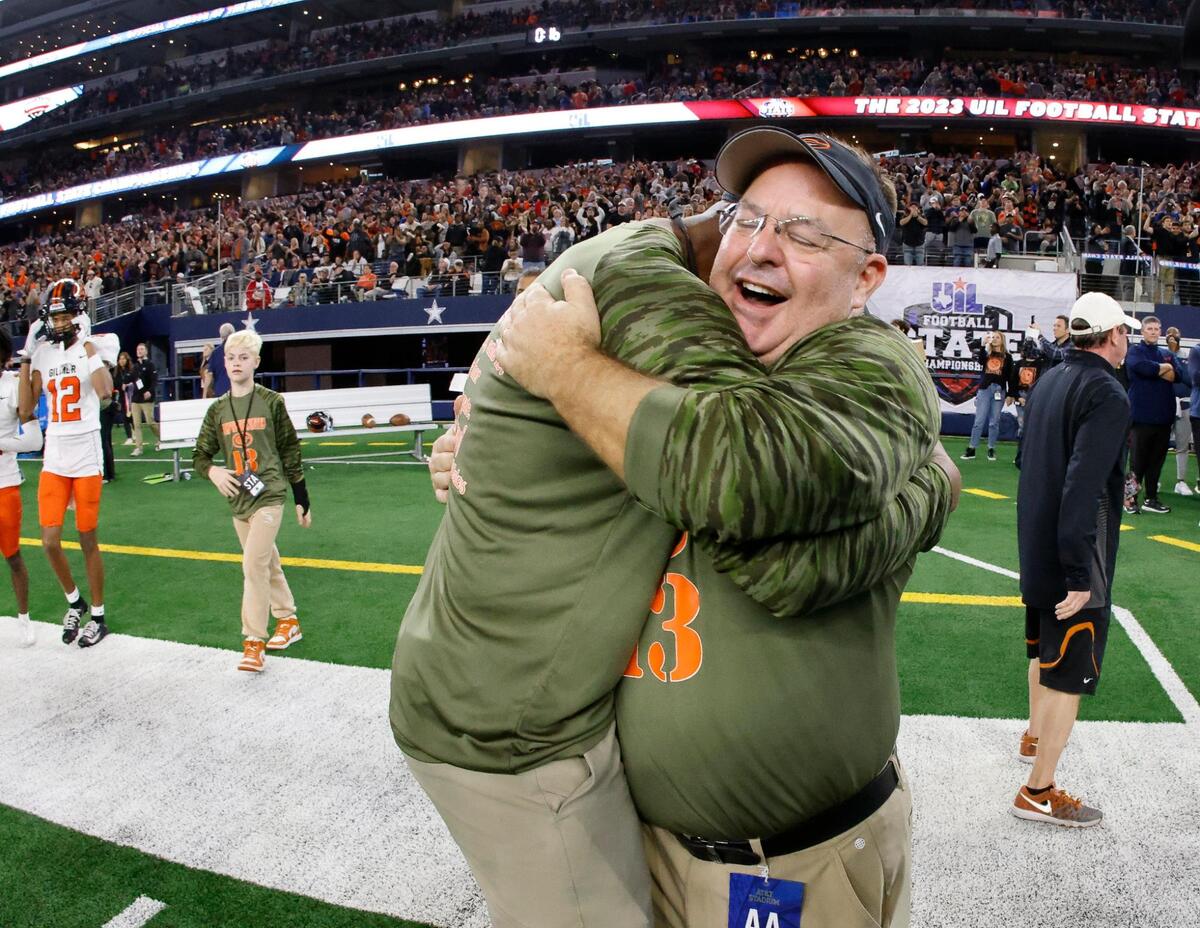 Gilmer head coach Alan Metzel gets a hug from an assistant coach after winning the UIL Conference 4A Division 2 state championship football game at AT&T Stadium in Arlington, Texas, Friday, Dec. 15, 2023.