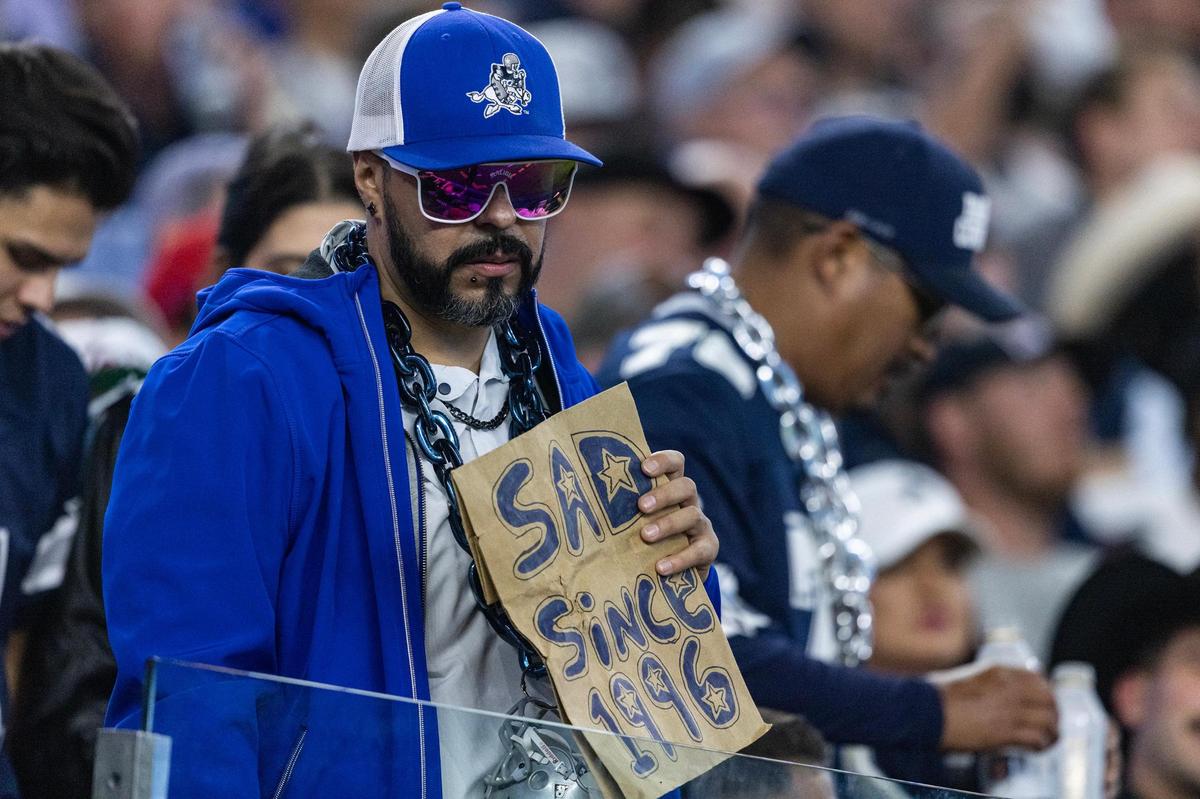 A Cowboys fan holds a sign saying “Sad Since 1996” during an NFL game between the Dallas Cowboys and the Houston Texans at AT&T Stadium in Arlington on Monday, Nov. 18, 2024.