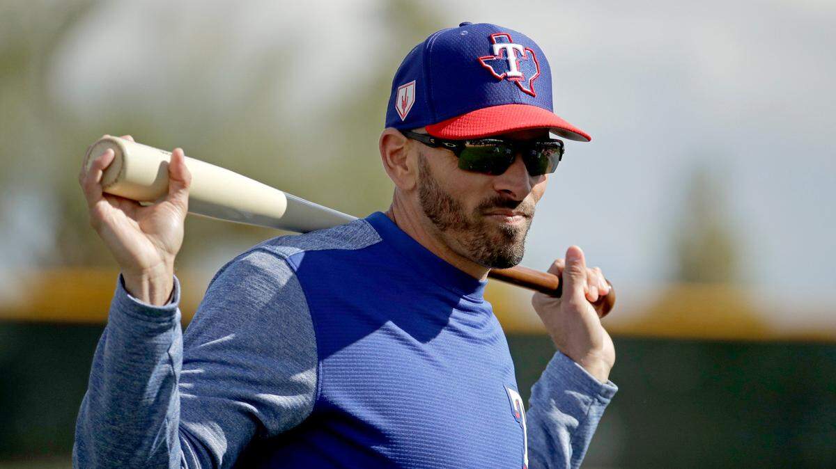 Texas Rangers manager Chris Woodward watches a drill during spring training baseball practice Monday, Feb. 18, 2019, in Surprise, Ariz. (AP Photo/Charlie Riedel)