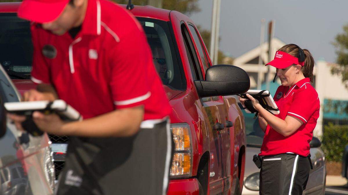 Chick-fil-A employees taking drive-thur orders.