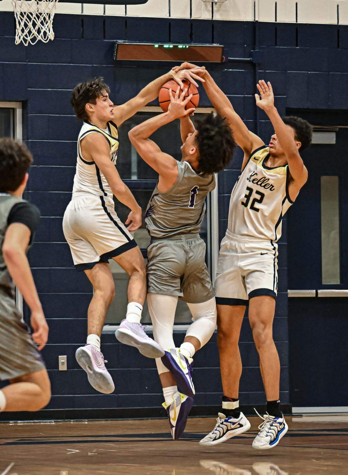 Keller’s Luke Fabian, left in white, and Seth Turnbull (32) block the shot of Keller Timber Creek’s Robert Moore (1) in a District 4-6A boys basketball game on Tuesday, January 28, 2025 at Keller High School in Keller, Texas.