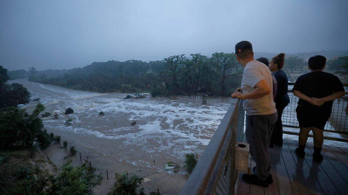 People watch the Guadalupe River, Saturday, July 5, 2025, in Kerrville, Texas. A flash flood swept through the area early Friday morning. 