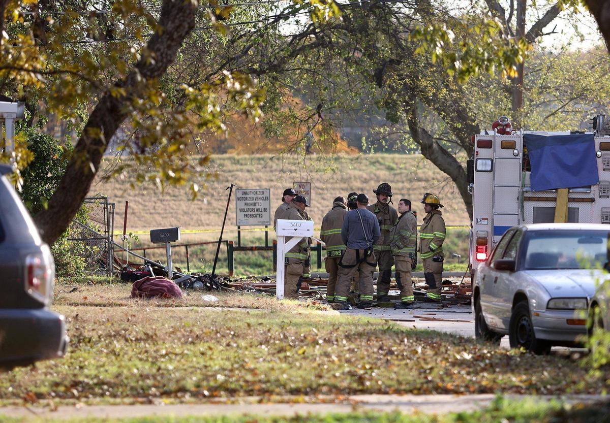 Members of the Fort Worth Fire Department stand in the street in front of the location where a house exploded on the 5600 block of Watters Place in Fort Worth on Thursday, December 1, 2022.