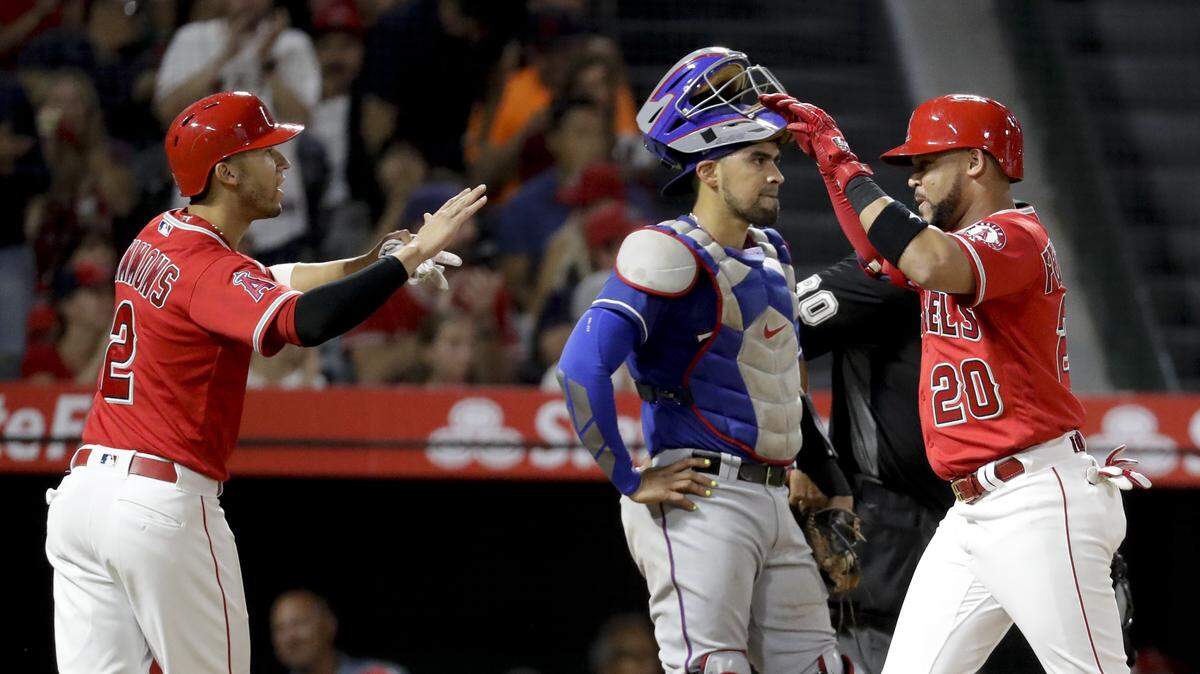 Jose Fernandez, left, connected for a two-run homer to cap the Angels’ four-run third inning Wednesday, and Rangers catcher Robinson Chirinos wasn’t too thrilled.