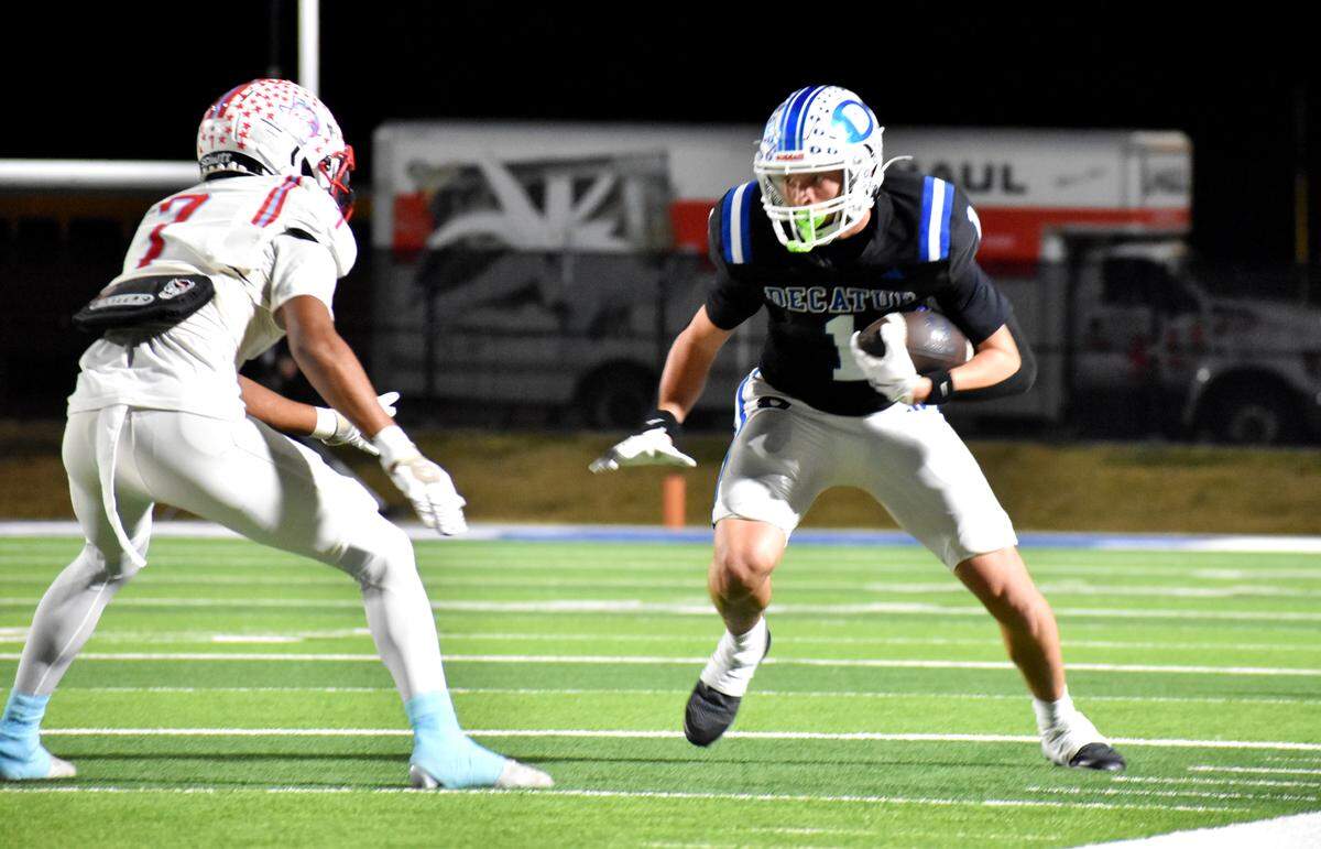 Decatur wide receiver Chase Berg looks for running room after a catch as River Oaks Castleberry’s Anthony Duron closes in for a tackle in the first quarter of a Class 4A Division I playoff game at Birdville ISD Fine Arts/Athletic Complex on Thursday, Nov. 13, 2025.