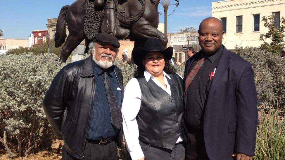 Sculptor Tomás Bustos, left, attorney Y. Leticia Sanchez Vigil, center, and sculptor David Newton in front of the Vaquero statue at North Main Street and Central Avenue at the statue’s dedication in 2012.